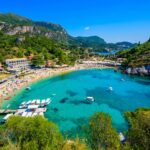 Agios Spiridon Beach with crystal clear azure water and white beach in beautiful landscape scenery – paradise coastline of Corfu island at Paleokastritsa, Ionian archipelago, Greece.